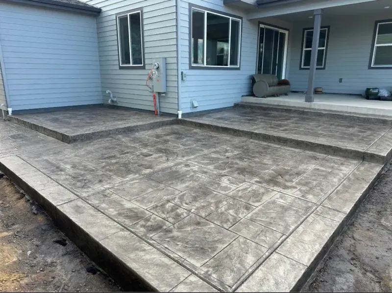 Stamped patio at a blue sided house, A & M Contracting