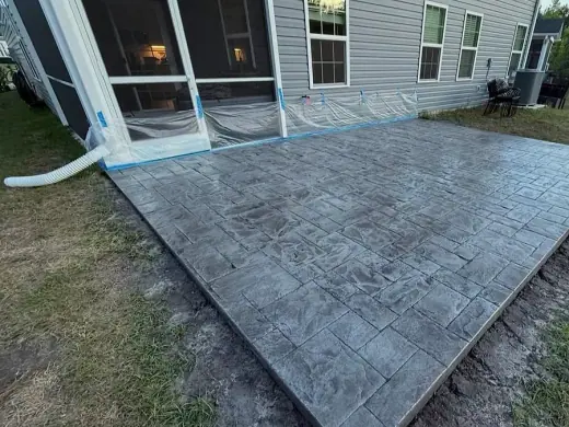 Stamped patio, windows still taped from the pour, A & M Contracting