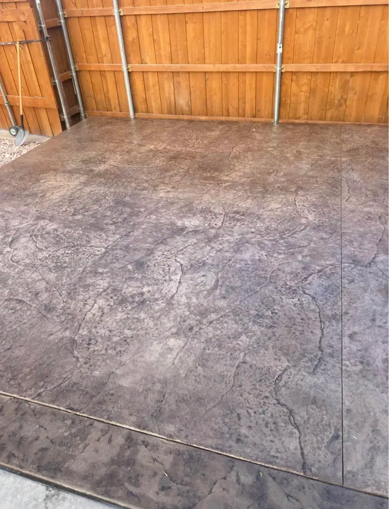 Red brown stamped patio inside a wood fence, A & M Contracting