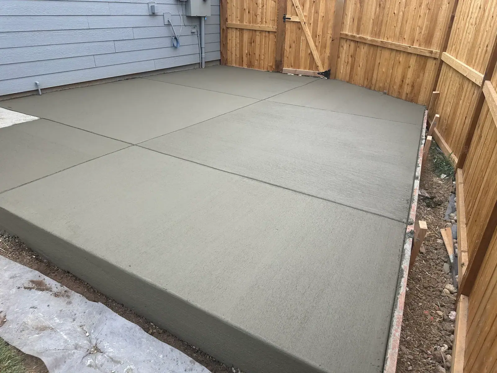 Jointed patio slab poured up to a cedar fence, A & M Contracting